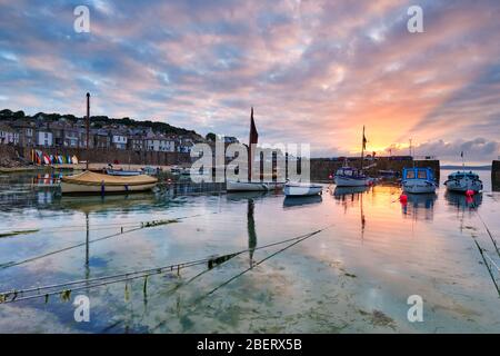 La lumière du soleil se brise dans le nuage du matin créant de beaux rayons dorés, Mousehole Banque D'Images