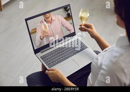 Date en ligne. Couple amoureux avec des verres de vin sur une distance de date en utilisant un ordinateur portable d'appel vidéo dans un cadre romantique à la maison. Saint-Valentin. Banque D'Images