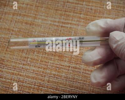 Légère augmentation de la température sur le thermomètre. 37,5 degrés Celsius. Température subfébrile. Début de la maladie. COVID-19. Banque D'Images