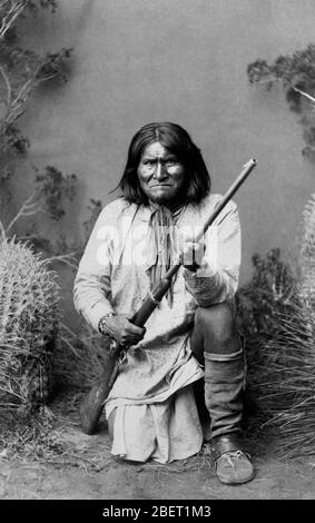 Portrait de Geronimo tenant un fusil lorsqu'il s'agenouille en 1886. Banque D'Images