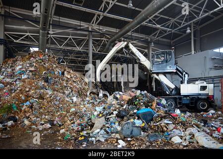 Minsk, Belarus - Octobre 2018 : processus de téléchargement de l'usine de recyclage de déchets convoyeur . Avec manipulateur grabber télécharge déchets sur convoyeur pour la furt Banque D'Images