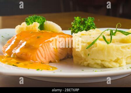 Repas de filet de saumon avec sauce aux fruits de la passion, brocoli et pommes de terre à la purée Banque D'Images