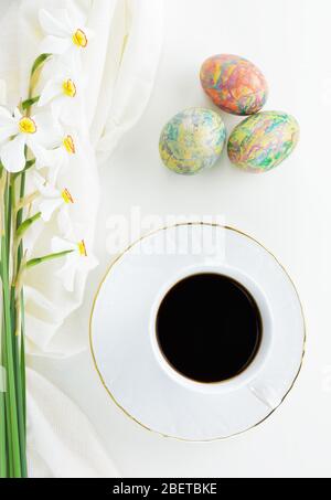 Oeufs de Pâques décorés, tasse de café noir et fleurs de Narcisse de Poet Banque D'Images