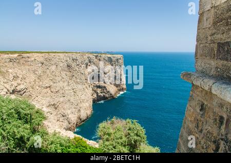 Portugal, Algarve, vue sur les falaises de Moher et de l'océan Atlantique, Cap Saint-Vincent, par une journée ensoleillée avec l'Atlantique bleu en arrière-plan, mur de pierre Banque D'Images