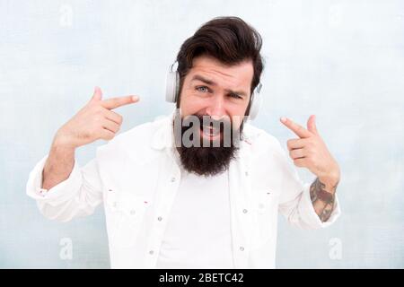 Technologie d'annulation active du bruit. Hipster écoute des écouteurs stéréo. Casque sans fil moderne. Pistes de musique de danse électroniques. Musique instrumentale. Casque homme barbu. Profitez de chaque note. Banque D'Images