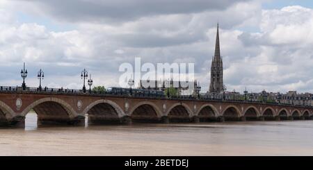 Bordeaux, Gironde / France - 05 26 2019 : tramway passant par le Pont de Pierre dans la Garonne et la basilique Saint Michel Bordeaux