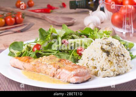 Filet de saumon, sauce aux fruits de la passion, riz et salade fraîche et saine sur une table en bois Banque D'Images