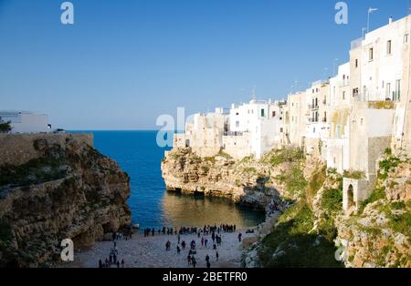 Vue sur la plage de lama monachile cala porto et des bâtiments blancs sur les grottes et les falaises dans la ville de Polignano a mare dans la région des Pouilles Pouilles, Souther Banque D'Images