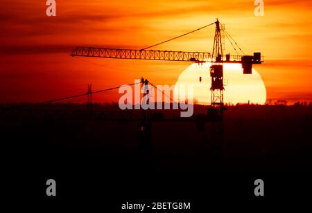 Munich, Allemagne. 15 avril 2020. Le soleil se couche derrière deux grues de construction. Crédit: Sven Hoppe/dpa/Alay Live News Banque D'Images