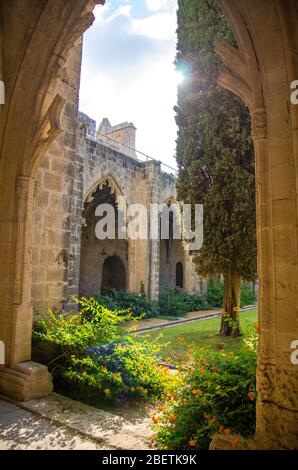 Ruines du monastère de l'abbaye de Bellapais à Kyrenia Girne avec des arches en pierre et des thujas, dans le nord de Chypre Banque D'Images