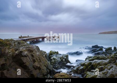 En regardant le port rocheux jusqu'à la vieille jetée de Portencross à Seamill West Kilbride sur une marche de tempête. Banque D'Images