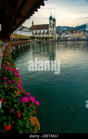 Vue sur le centre historique de la ville de Luzern et la rivière Reuss depuis le célèbre pont de la Chapelle en bois avec fleurs fleuries, le plus ancien pont couvert en bois en EUR Banque D'Images