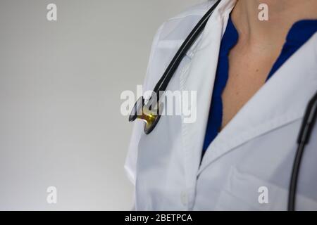 Gros plan sur le manteau blanc et le stéthoscope sur le travailleur médical isolé sur fond gris Banque D'Images