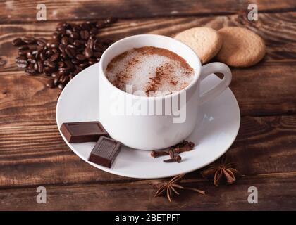 un bouchon de café avec mousse, gâteaux, grains de café en forme de coeur sur la table en bois. Plat avec pas de personnes Banque D'Images