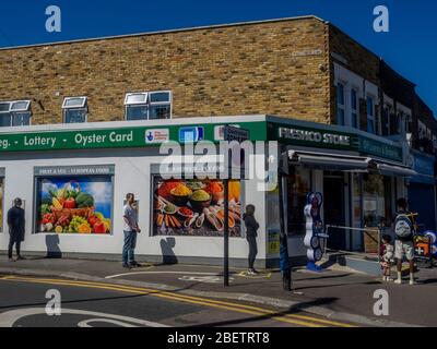 Londres. ROYAUME-UNI. 5 avril 2020. Vue des gens qui font la queue dans un magasin de Francis Road, Leyton (East London). Banque D'Images