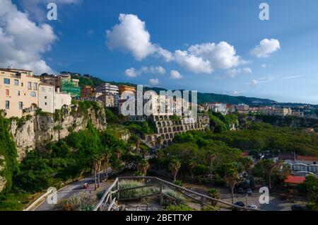 Tropea ville, arbres verts dans le parc, bâtiments colorés sur le haut de la grande falaise abrupte de roche, vue de l'église Sanctuary de Santa Maria dell Isola, Vibo V Banque D'Images