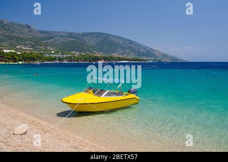 Bateau jaune sur la belle mer près de la plage de cape Zlatni Rat (Corne d'Or) de l'île de Brac, mer Adriatique, Croatie Banque D'Images