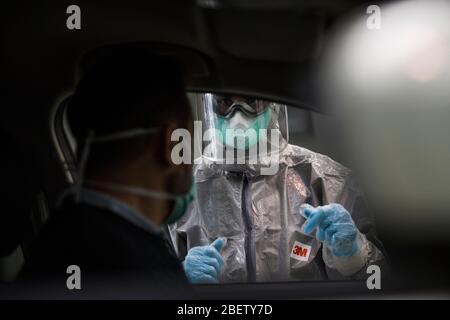 Un professionnel de la santé dans une combinaison protectrice prend un échantillon pour un test PCR.pendant la crise du coronavirus, au centre de l'ITV (inspection technique des véhicules) dans les tests PCR Albolote (réaction en chaîne de la polymérase) sont effectués sur les travailleurs des forces de sécurité et le personnel des maisons de soins infirmiers pour détecter Covid 19. Banque D'Images