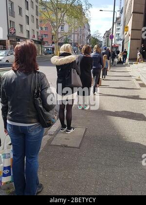 File d'attente ou ligne d'attente des personnes à la poste et entrée au supermarché avec 1,5 mètres de distance de sécurité / 6 pieds de séparation - virus corona covid-19 Banque D'Images