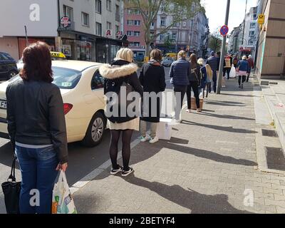 File d'attente ou ligne d'attente des personnes à la poste et entrée au supermarché avec 1,5 mètres de distance de sécurité / 6 pieds de séparation - virus corona covid-19 Banque D'Images