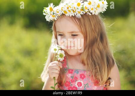 Un enfant avec une couronne de fleurs. Banque D'Images