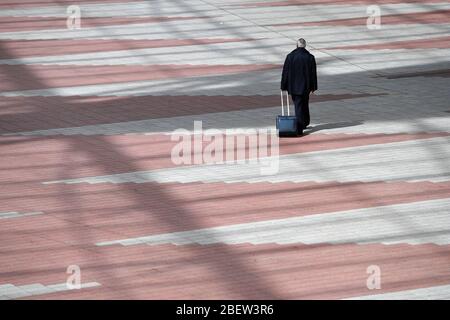 Photo thématique pandémie de coronavirus le 15 avril 2020. Aéroport Franz Josef Strauss de Munich. Aéroport de Munich. Un voyageur unique avec des promenades en tramway dans une zone pavée du centre de l'aéroport de Munich, dans le centre. | utilisation dans le monde entier Banque D'Images