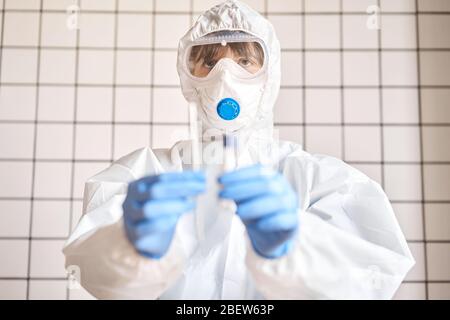 Tube de test pour écouvillon de maintien pour analyse 2019-nCoV. Test de coronavirus. Gants médicaux bleus et masque de protection pour la protection contre le covid-19 Banque D'Images