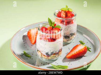 Yaourt granola parfait avec fraises sur plat Banque D'Images