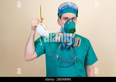 Le médecin en costume vert et les masques respiratoires sont muni d'un masque de protection respiratoire médical blanc . Concept médical. Banque D'Images