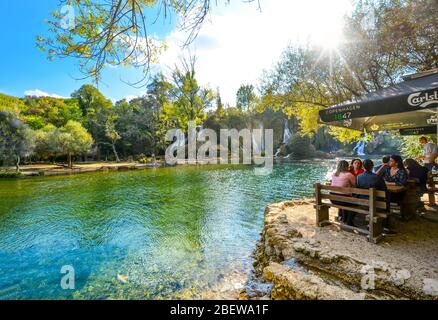 Un groupe de touristes féminins se détendent à une table de café au bord de la rivière, le long des chutes de Kravica ou de Kravice en Bosnie-Herzégovine. Banque D'Images