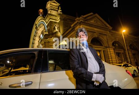 10 avril 2020, Hessen, Francfort-sur-le-Main: Ahmed Mansoor, chauffeur de taxi, se tient à son véhicule avec un masque respiratoire. La crise de Corona frappe durement les entreprises de taxis, de nombreux entrepreneurs craignent pour leur existence. Les ventes de chauffeurs de taxi individuels auraient chuté d'environ 90 %. (À dpa 'Association de taxi craint l'insolvabilité à la suite de la pandémie de Corona') photo: Andreas Arnold/dpa Banque D'Images