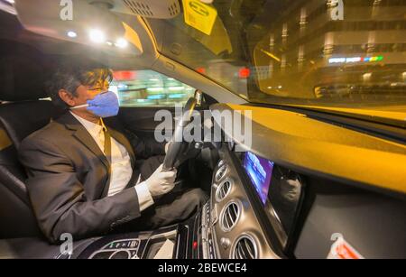 10 avril 2020, Hessen, Francfort-sur-le-Main: Ahmed Mansoor, chauffeur de taxi, est assis dans son véhicule et porte un respirateur. La crise de Corona frappe durement les entreprises de taxis, de nombreux entrepreneurs craignent pour leur existence. Les ventes de chauffeurs de taxi individuels auraient chuté d'environ 90 %. (À dpa 'Association de taxi craint l'insolvabilité à la suite de la pandémie de Corona') photo: Andreas Arnold/dpa Banque D'Images