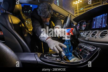 10 avril 2020, Hessen, Francfort-sur-le-Main: Ahmed Mansoor, chauffeur de taxi, atteint pour les produits de nettoyage après une course en taxi. La crise de Corona frappe durement les entreprises de taxis, de nombreux entrepreneurs craignent pour leur existence. Le chiffre d'affaires des chauffeurs de taxi individuels aurait chuté d'environ 90 %. (À dpa 'Association de taxi craint l'insolvabilité à la suite de la pandémie de Corona') photo: Andreas Arnold/dpa Banque D'Images