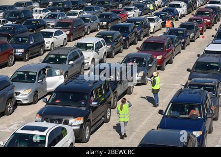 Les conducteurs de centaines de véhicules attendent que les volontaires de la Banque alimentaire du Texas central livrent des boîtes de 28 livres d'agrafes lors d'un don alimentaire à Austin, Texas. Près de 1 500 familles ont pris des boîtes en réponse à de nombreuses pertes d'emploi dues à la pandémie de coronavirus et aux retombées économiques générales du Texas. Banque D'Images