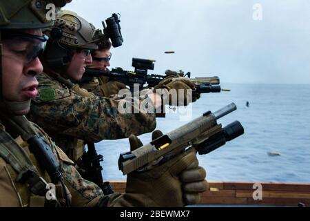 MER DES PHILIPPINES (15 avril 2020) les marines avec les 31 fusils de service M4 et les pistolets de service M45 A pendant une répétition rapide de tir de corde et de pont à bord du navire d'assaut amphibie USS America (LHA 6). L'entraînement a simulé un encart hélicoptère dans une visite opposée, un conseil, une recherche et une saisie, l'un des principaux ensembles de mission de la MRF. L'Amérique, phare du America Expeditionary Strike Group, 31 membres de l'équipe du MEU, opère dans la 7ème zone d'opérations de la flotte américaine pour améliorer l'interopérabilité avec ses alliés et ses partenaires et servir de r prêt Banque D'Images