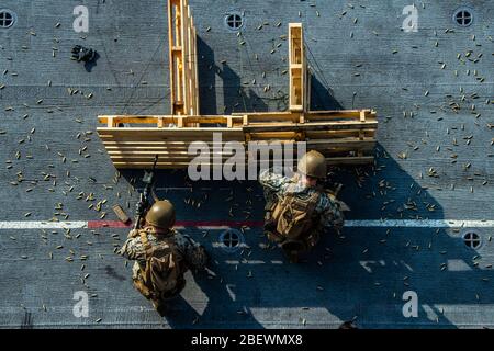 MER DES PHILIPPINES (15 avril 2020) les marines avec les 31 fusils de service MUE (Marine Expeditionary Unit) ont incendié des fusils de service MRF pendant une répétition rapide de tir sur corde et pont à bord d'un navire d'assaut amphibie USS America (LHA 6). L'entraînement a simulé un encart hélicoptère dans une visite opposée, un conseil, une recherche et une saisie, l'un des principaux ensembles de mission de la MRF. L'Amérique, phare du America Expeditionary Strike Group, 31 Meu Team, opère dans la 7ème zone d'opérations de la flotte américaine pour améliorer l'interopérabilité avec les alliés et les partenaires et servir de force de réponse prête à défendre pe Banque D'Images