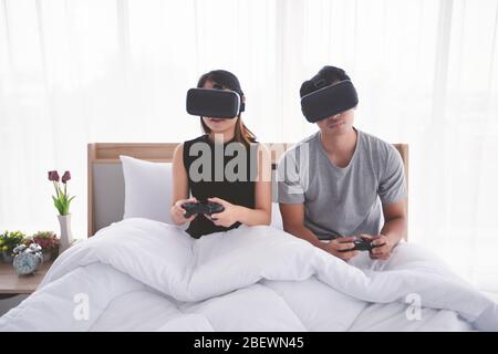 Les amoureux des couples asiatiques Qui Aiment Jouer au jeu Videogame dans la chambre de lit, les amoureux des couples asiatiques se sentent heureux plaisir et réalité virtuelle, VR jouer à des jeux ensemble pendant l Banque D'Images