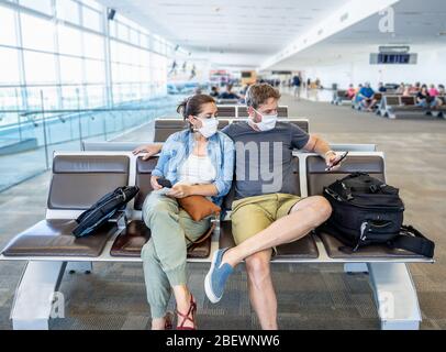 COVID-19 fermetures de frontières mondiales. Couple avec masque de visage coincé dans le terminal de l'aéroport après avoir été refusé l'entrée à d'autres pays. Passagers coincés Banque D'Images