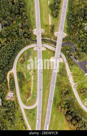 Vue aérienne sur une intersection de route avec des voitures en mouvement. Photographie de drone de route de pays en Biélorussie Europe Banque D'Images