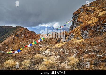 De petits tas de pierres et de drapeaux de prière Tibetains Lung Ta au camp de base à l'Himal Mardi Nuageux sommets de montagnes de l'Himalaya au Népal Banque D'Images