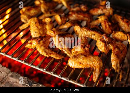 De délicieuses ailes de poulet Chili sur un gril. Viande de poulet épicée chaude rôtie au charbon de bois. Profondeur de champ peu profonde Banque D'Images