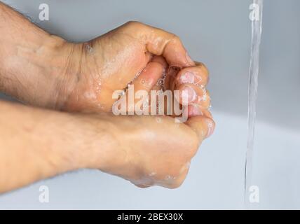 Gros plan homme lave ses mains, l'eau du robinet verse Banque D'Images