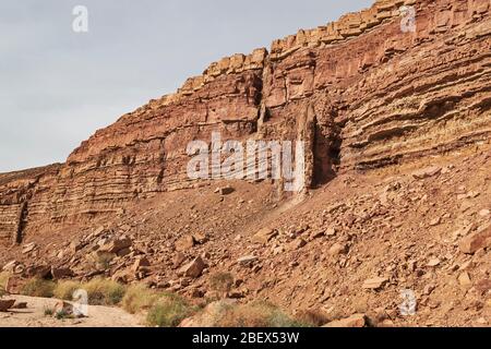 détail géologique de la falaise à côté de wadi ardon dans le cratère de makhtesh ramon montrant deux dykes magma avec le lit de ruisseau en premier plan Banque D'Images