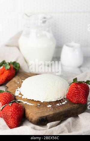 Préparation maison, fromage à la crème naturel fait maison sur fond clair sur un panneau en bois Banque D'Images