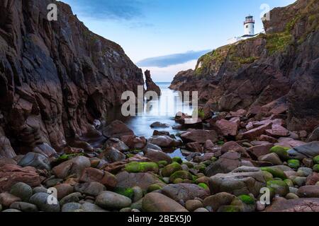 Vue sur un coucher de soleil depuis la crique sous le phare de Fanad Head (Fánaid), County Donegal, région d'Ulster, Irlande, Europe. Banque D'Images