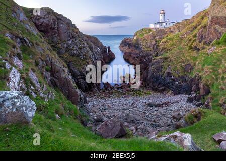 Vue sur un coucher de soleil depuis la crique sous le phare de Fanad Head (Fánaid), County Donegal, région d'Ulster, Irlande, Europe. Banque D'Images