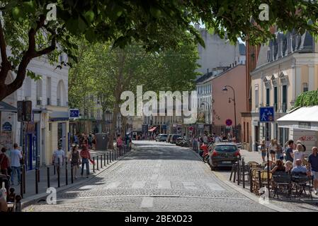 Paris, France. Rue française typique du quartier de Montmartre avec une foule de touristes, cafés et restaurants près de la basilique du Sacré-cœur. Banque D'Images