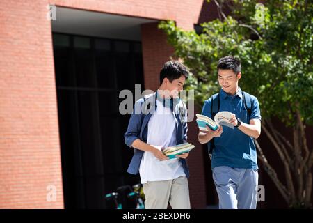 Le campus marchez sur la route pour explorer l'apprentissage de jeune homme à l'intérieur Banque D'Images