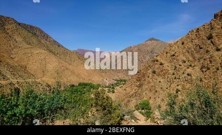 STI Fadma/Maroc - 10.03.2019: Vue sur la vallée de l'Ourika et un petit village caché entre les montagnes. Atlas montagnes par une journée ensoleillée. Banque D'Images
