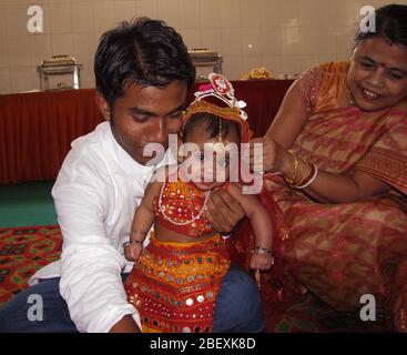 Cérémonie d'alimentation du riz - un bébé indien vêtu de robe rouge pour sa cérémonie Annaprashan aussi appelé Mukhe Bhaat Banque D'Images